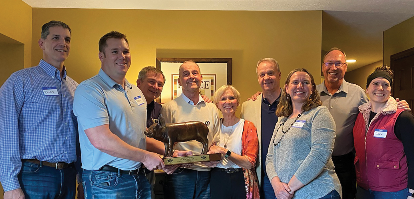 Group of people standing with a statuette of a pig