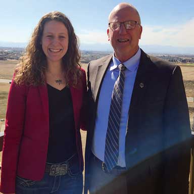 Two people standing outdoors facing the camera