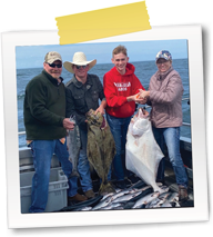 Four people holding a large fish in front of the ocean (Dr. Baysinger on right)